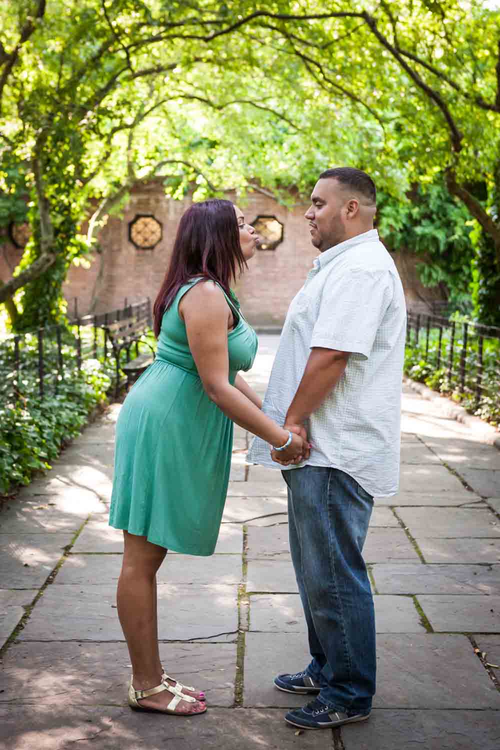 Couple standing in Conservatory Garden walkway holding hands during a Central Park engagement shoot