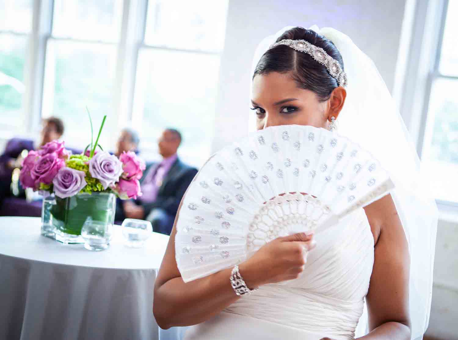 Bride looking over fan at an Attic Studios wedding