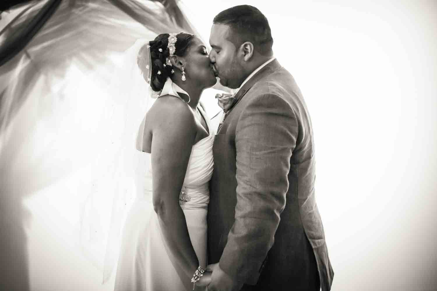 Black and white photo of bride and groom kissing at Attic Studios ceremony