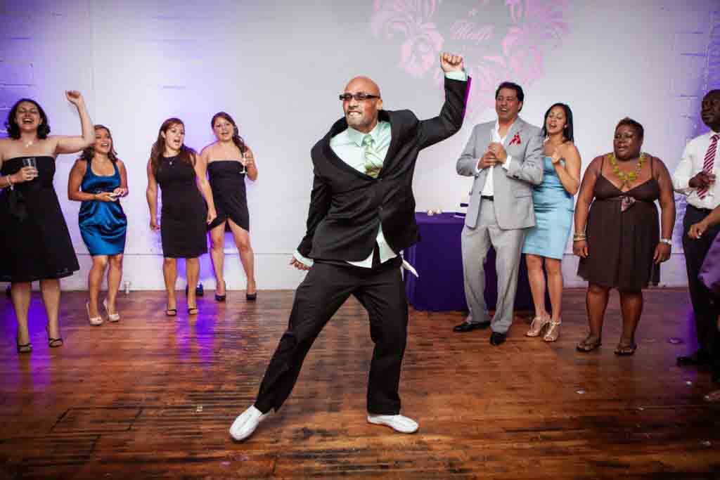 Man dancing in circle of guests at an Attic Studios wedding