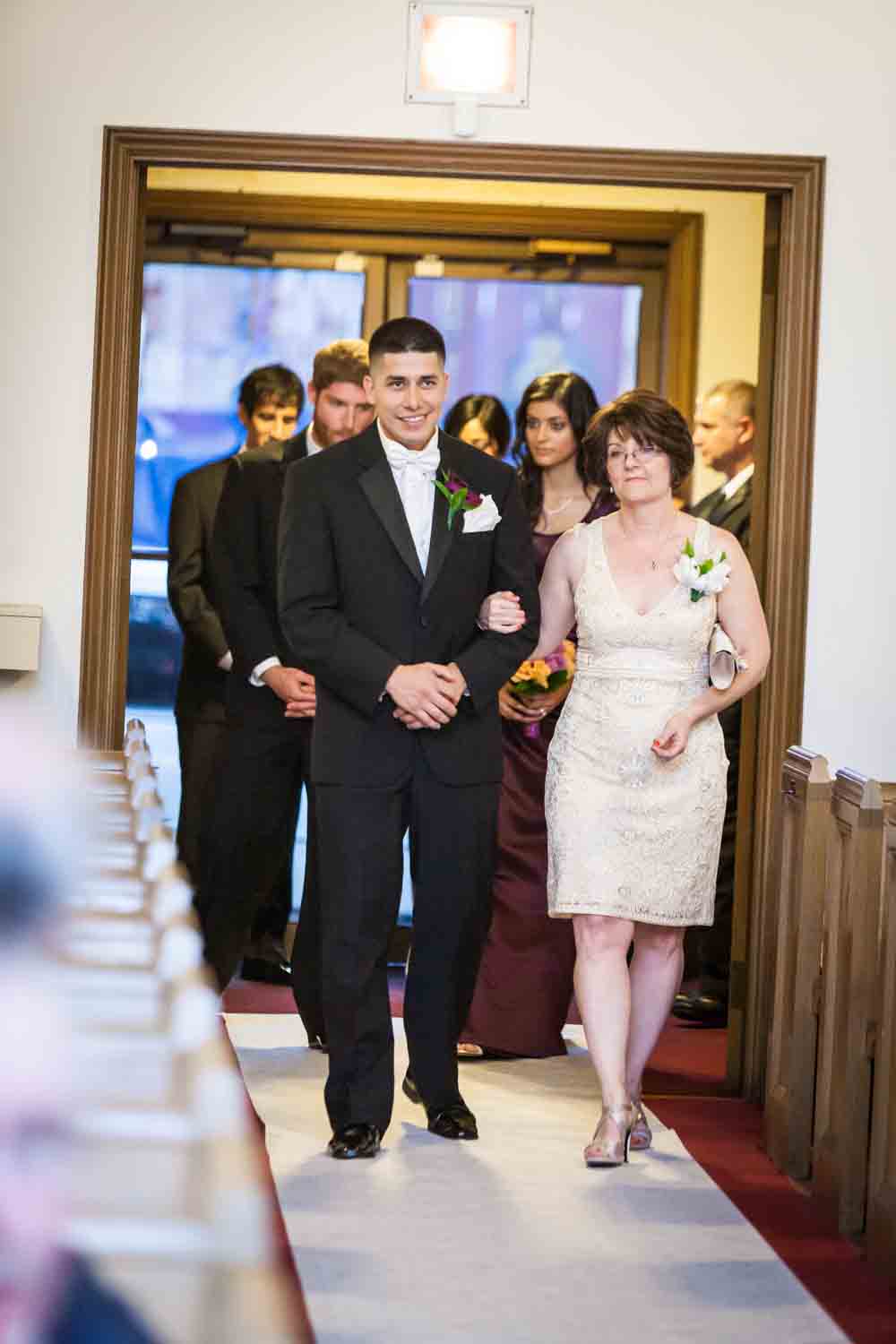 Groom and mother walking down aisle of church at a Fort Hamilton Community Center wedding