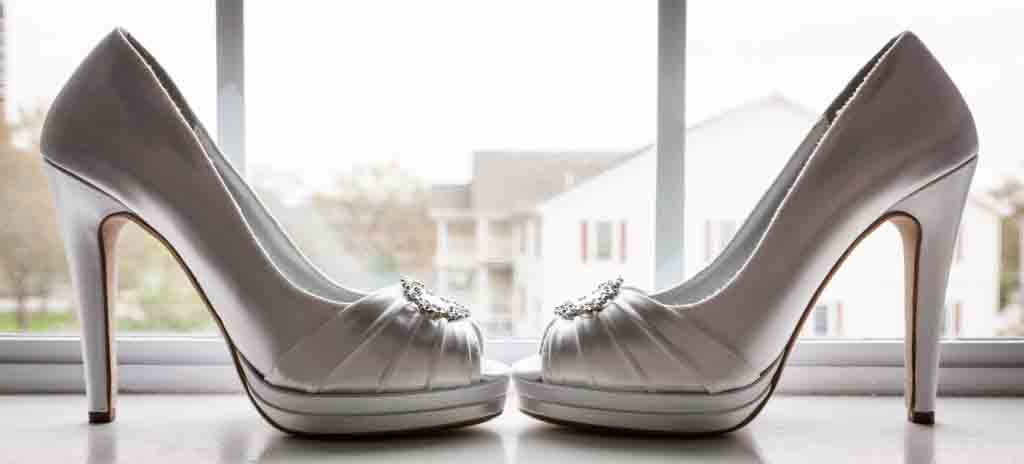 Close up of white satin heels in a windowsill