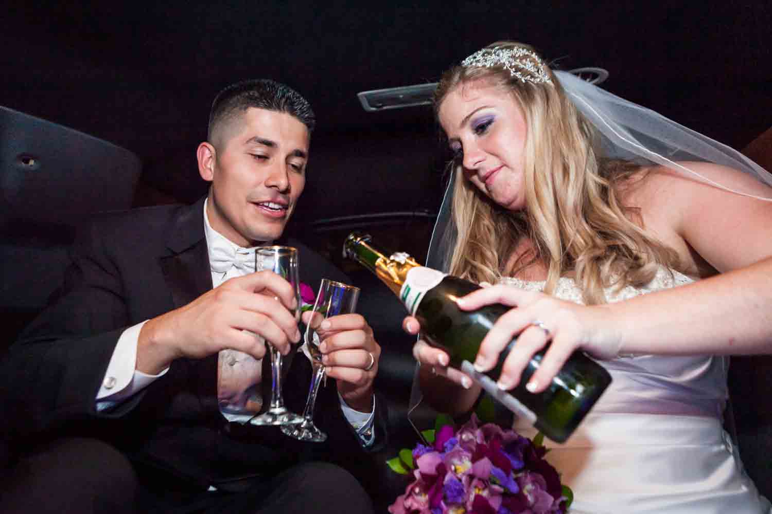Bride pouring champagne into glasses held by groom