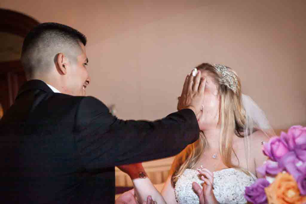 Groom smashing cake into bride's face at a Fort Hamilton Community Center wedding