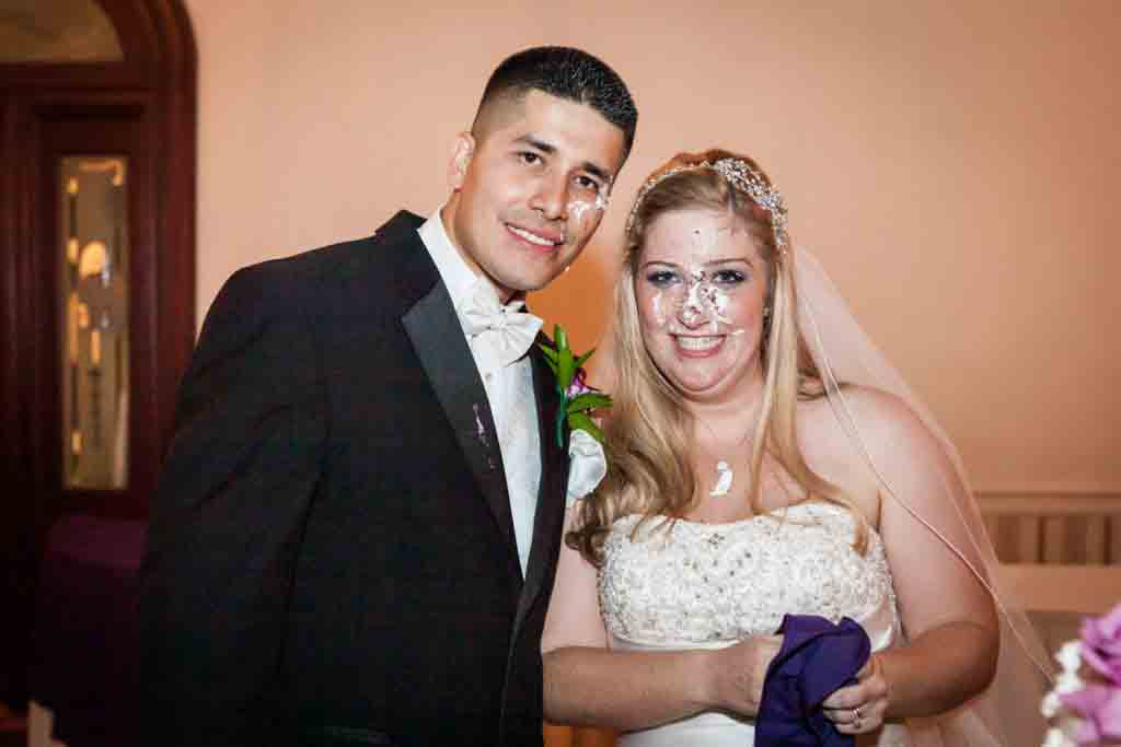 Bride and groom with cake on their faces at a Fort Hamilton Community Center wedding