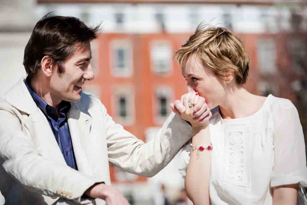 Woman kissing man's hand in Washington Square Park