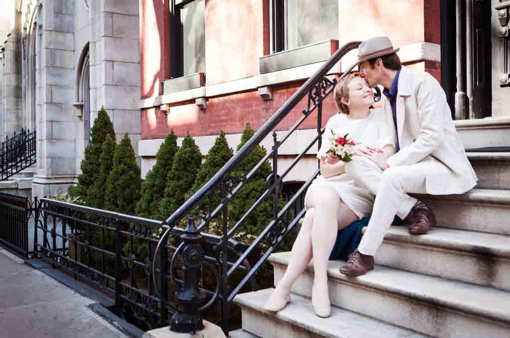 Man kissing woman on side of head while sitting on steps