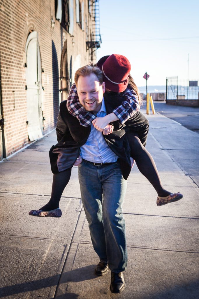 Red Hook engagement photos of man giving woman a piggyback ride