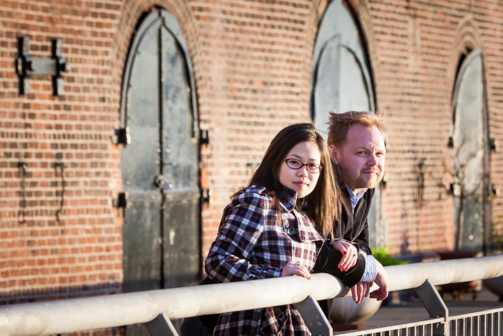 Red Hook engagement photos of couple leaning on railing