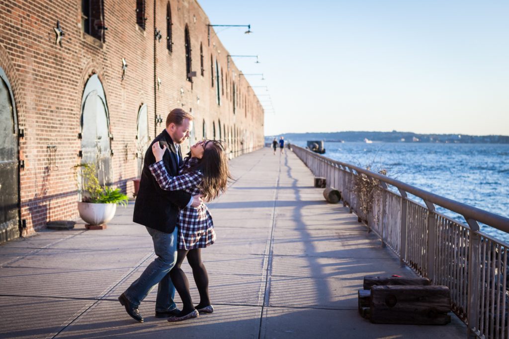Red Hook engagement photos of couple dancing in front of brick building