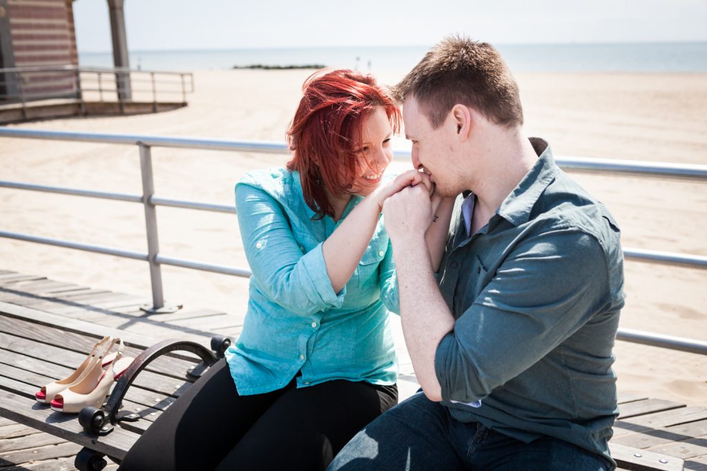 Coney Island engagement photos of man kissing woman's hand