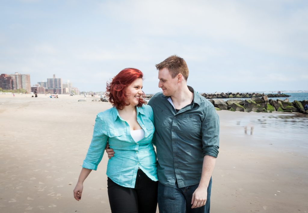 Coney Island engagement photos of couple walking on beach