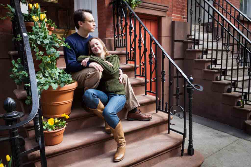 Couple cuddling on brownstone stairs in Greenwich Village