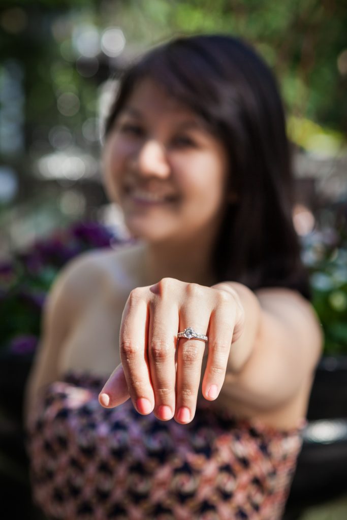Woman holding hand out wearing engagement ring