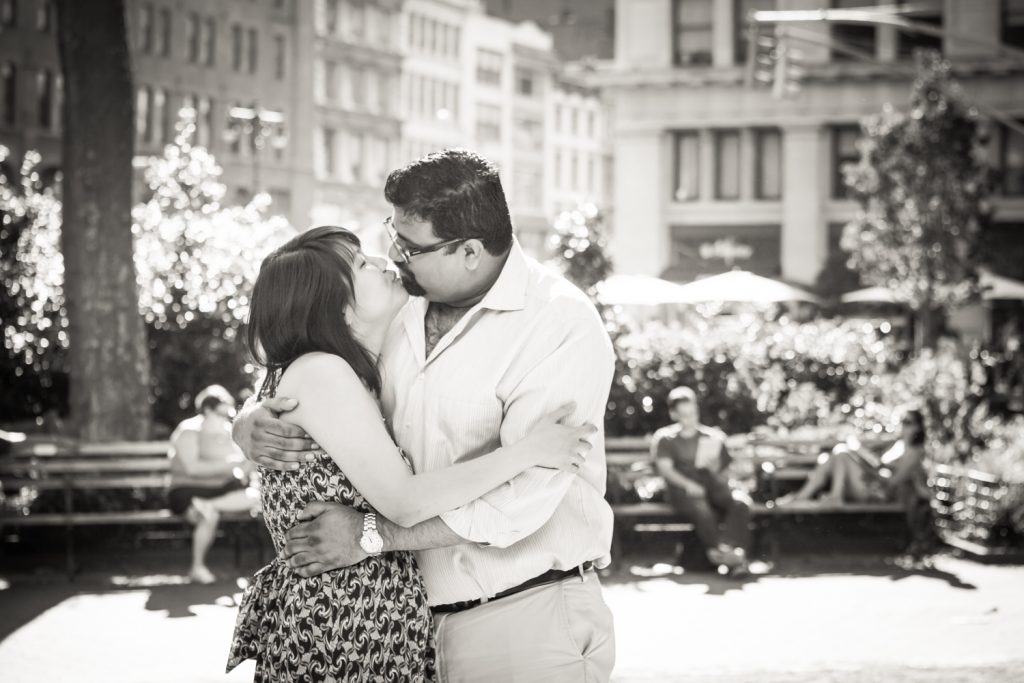 Black and white photo of couple kissing in Madison Square Park