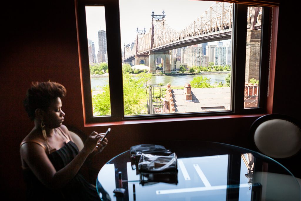 Guest sitting in front of window with Queensborough Bridge in background