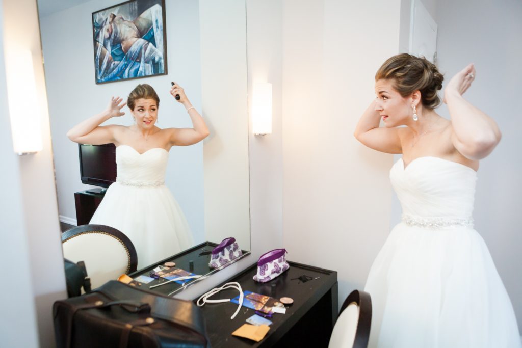 Bride looking at her hair in the mirror before a Ravel Hotel Penthouse wedding