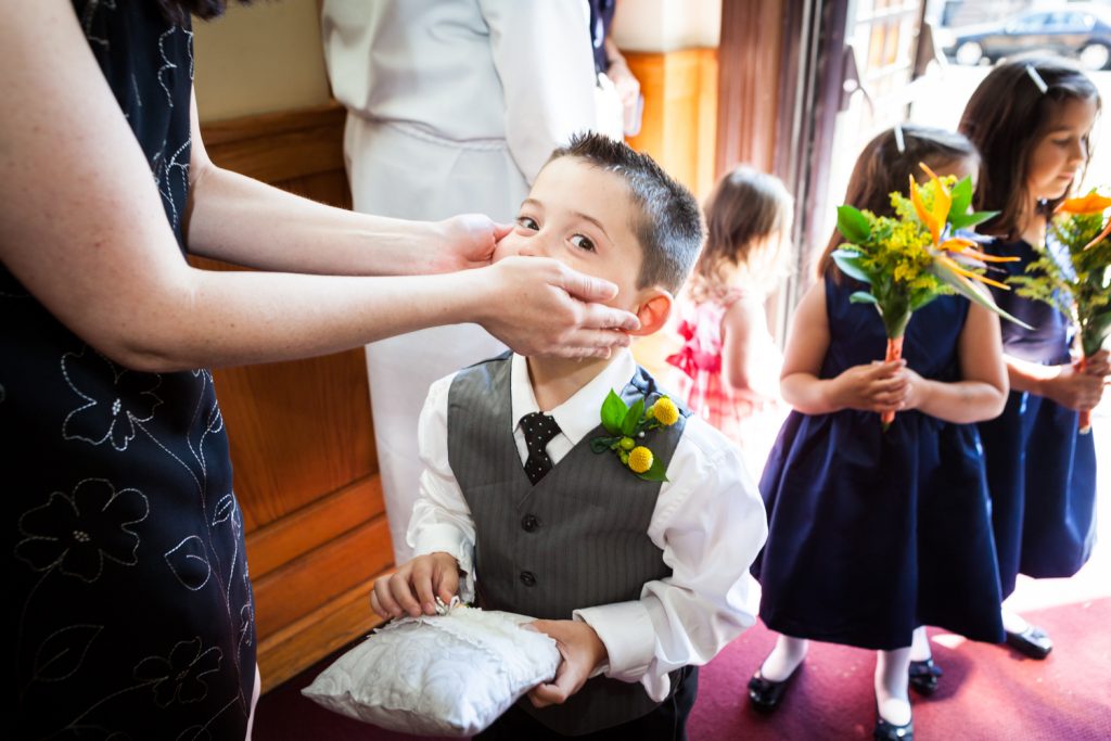 Close up of woman holding little ring bearer's face