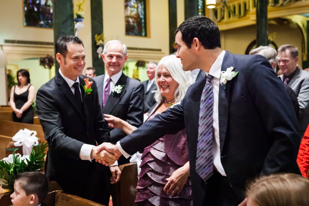 Groom shaking hands with family members in St. Joseph's Church
