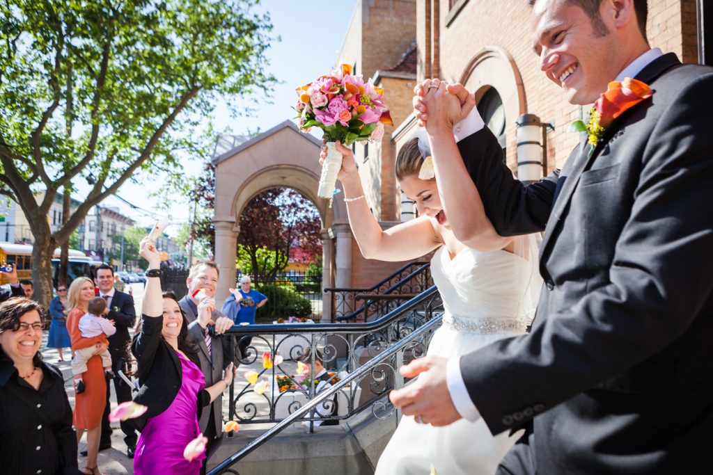 Bride and groom leaving St. Joseph's Church and guests throwing rose petals