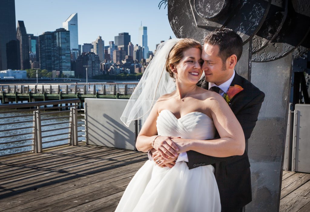 Bride and groom hugging in Gantry Plaza State Park during a Ravel Hotel Penthouse wedding