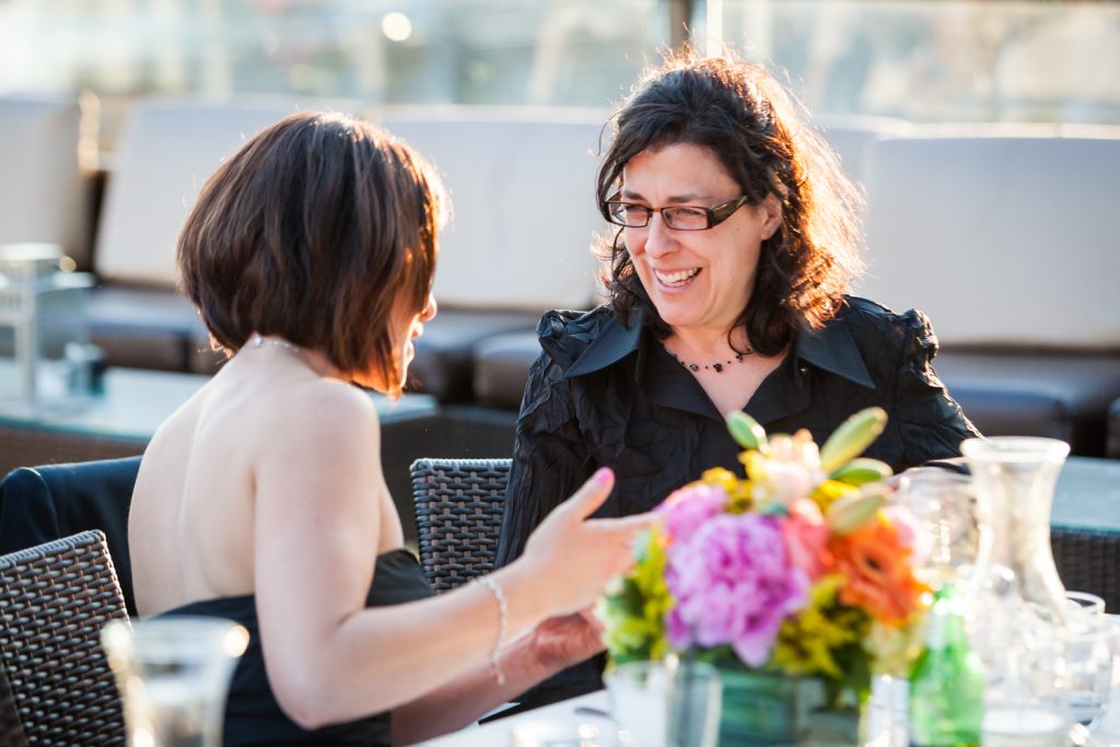 Two female guests talking at a Ravel Hotel Penthouse wedding