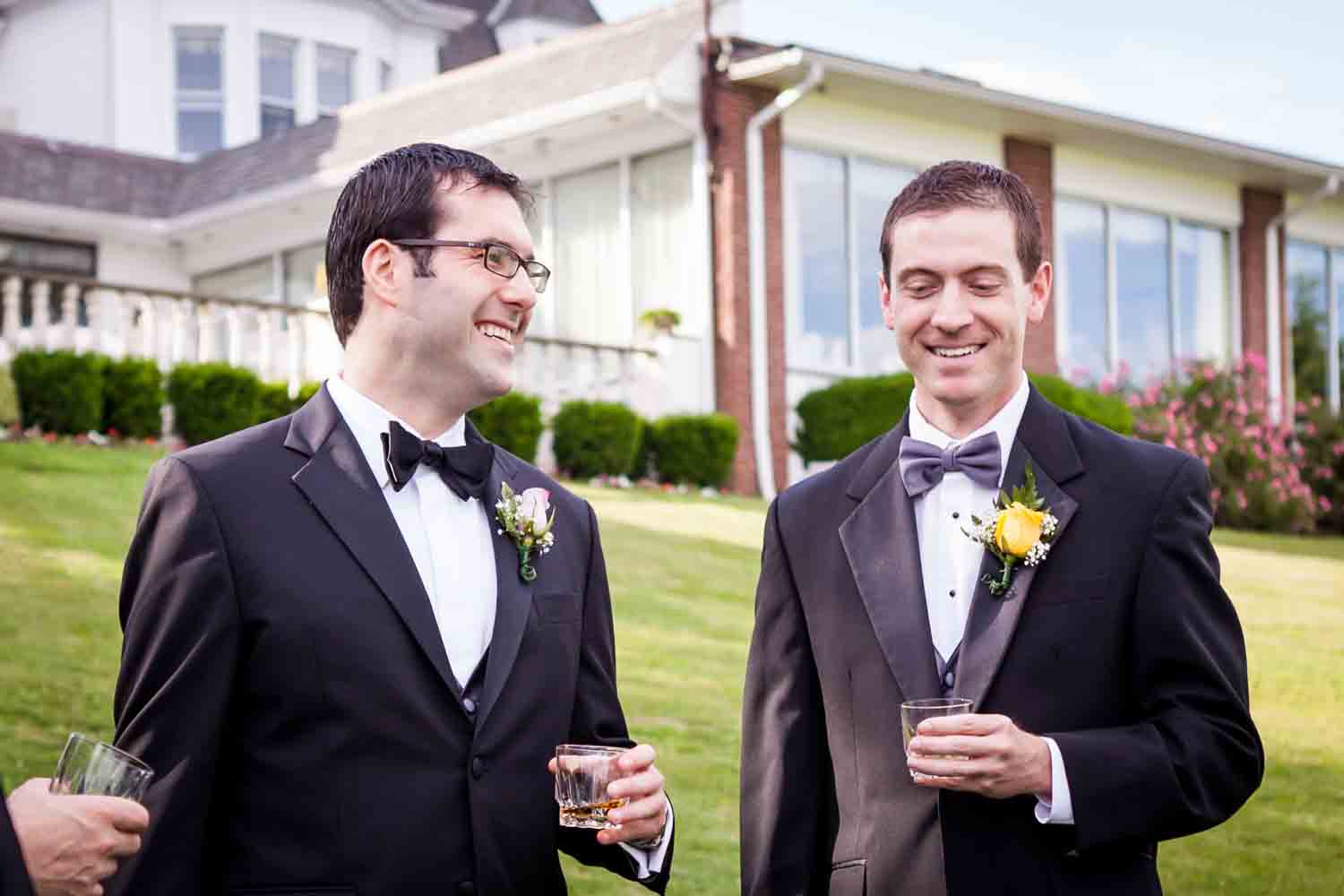 Groom and groomsmen drinking on front lawn at a Davenport Mansion wedding