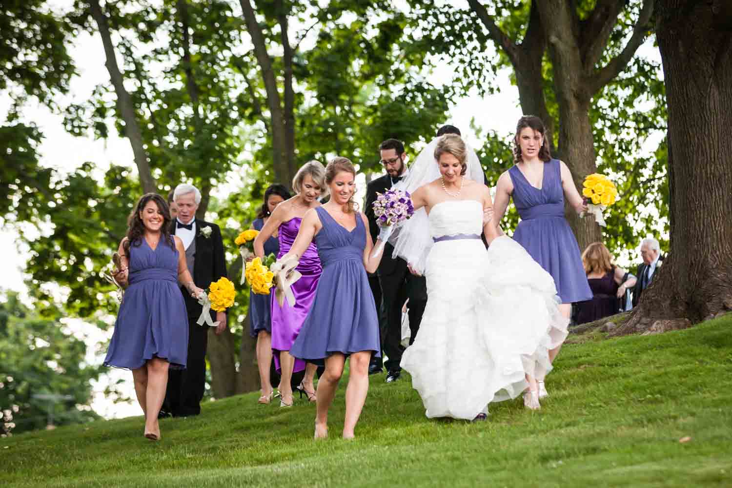 Bride and bridal party walking across lawn at a Davenport Mansion wedding