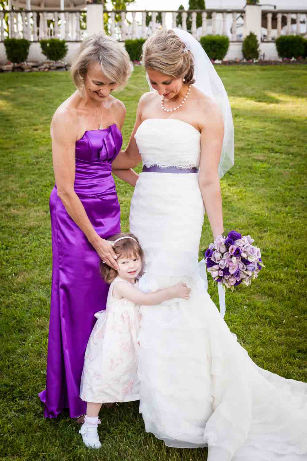 Little girl hugging bride standing by her mother at a Davenport Mansion wedding