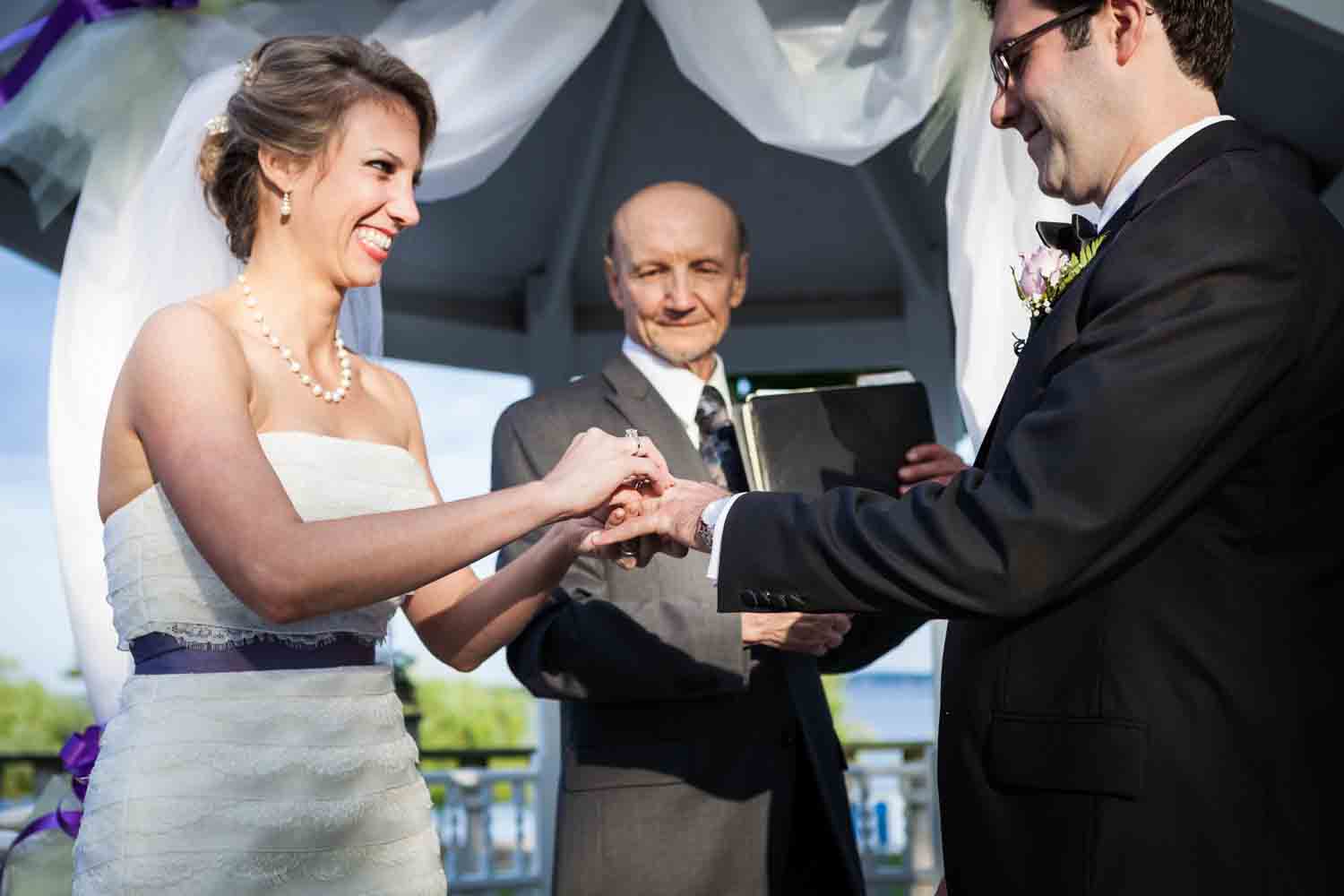 Bride putting ring on groom's finger at a Davenport Mansion wedding