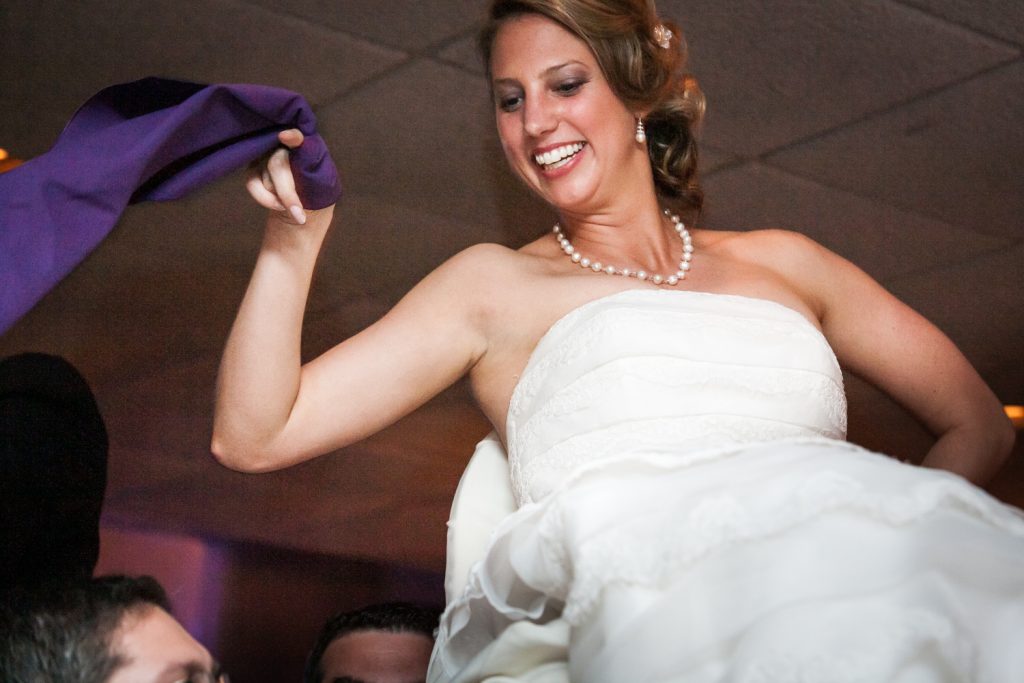 Bride lifted on chair during hora at a Davenport Mansion wedding