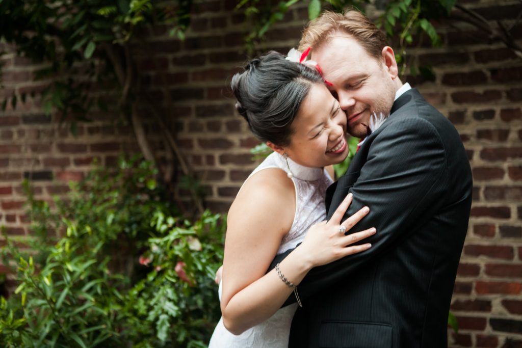 Bride and groom hugging in garden patio at a Merchant's House Museum wedding