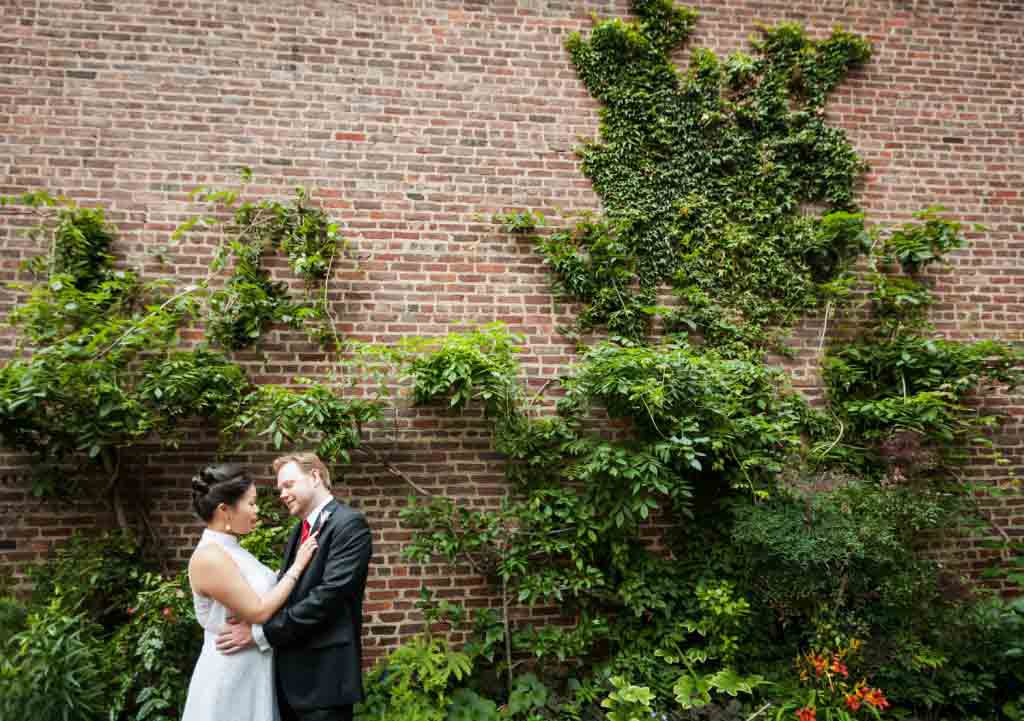 Bride and groom hugging in garden patio at a Merchant's House Museum wedding