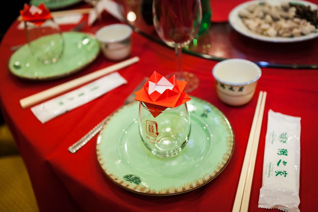 Table setting with green plate and origami at a Congee Village wedding reception