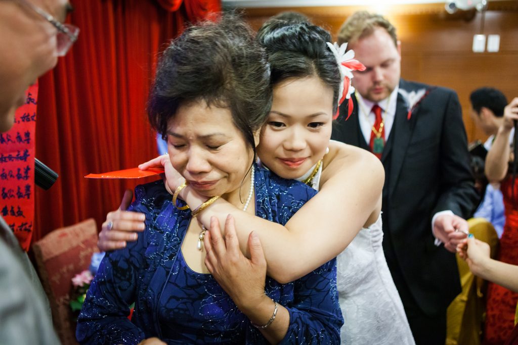 Bride hugging mother during fujisan gold ceremony at Congee Village wedding reception