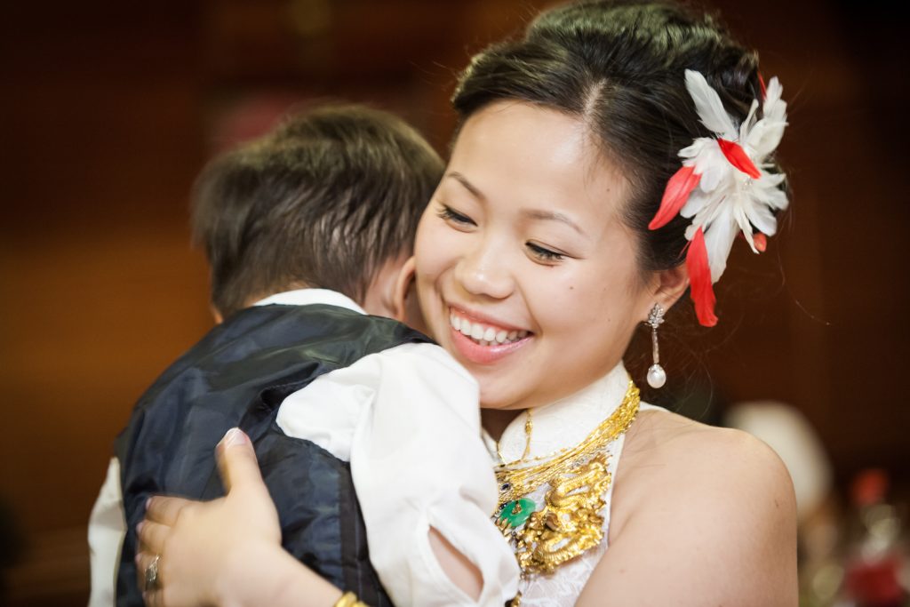 Bride hugging little boy at a Congee Village wedding reception