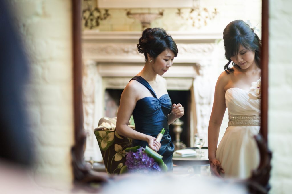 Bride and maid of honor reflected in mirror at an Alger House wedding