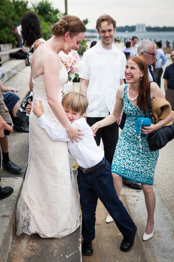 Little boy hugging bride at a Brooklyn Bridge Park wedding