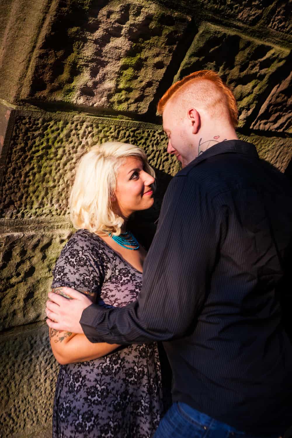 Central Park engagement photos of couple leaning against side of Trefoil Arch
