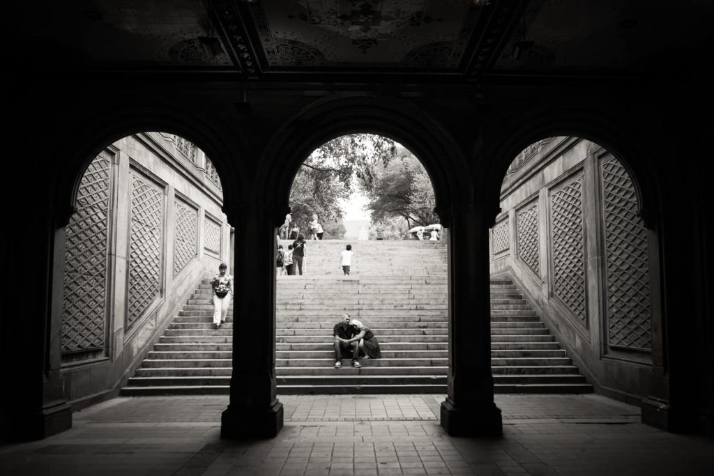 Black and white photo of couple sitting on stairs in Bethesda Arcade