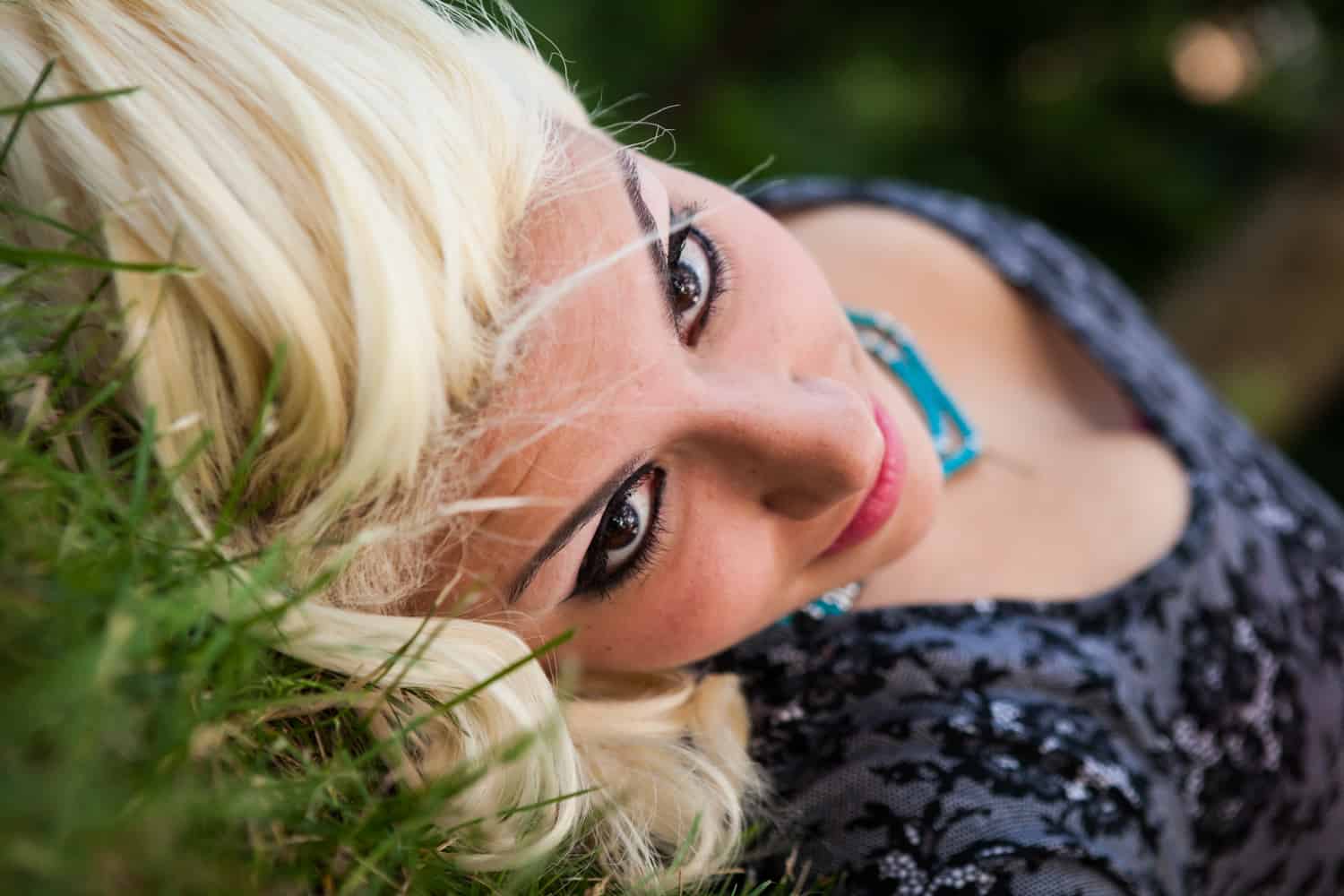 Woman with blonde hair laying in the grass in Central Park