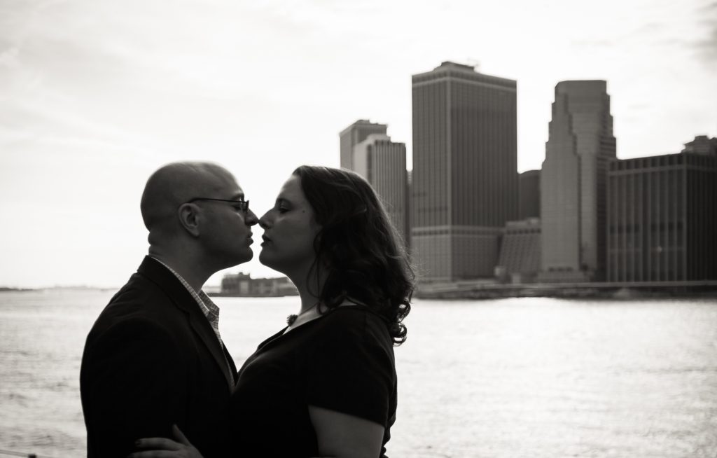 Black and white photo backlit couple with NYC skyline in background