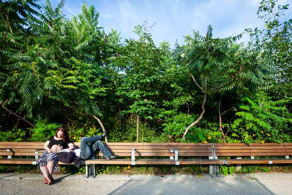 Wide shot of couple sitting on bench in Brooklyn Bridge Park
