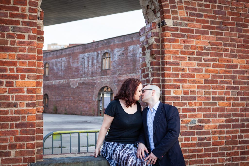 Couple kissing against brick wall