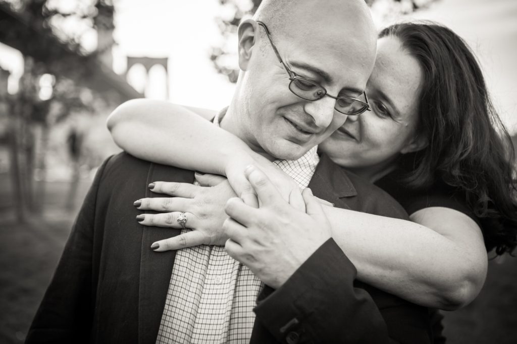 Black and white photo of woman hugging man from behind