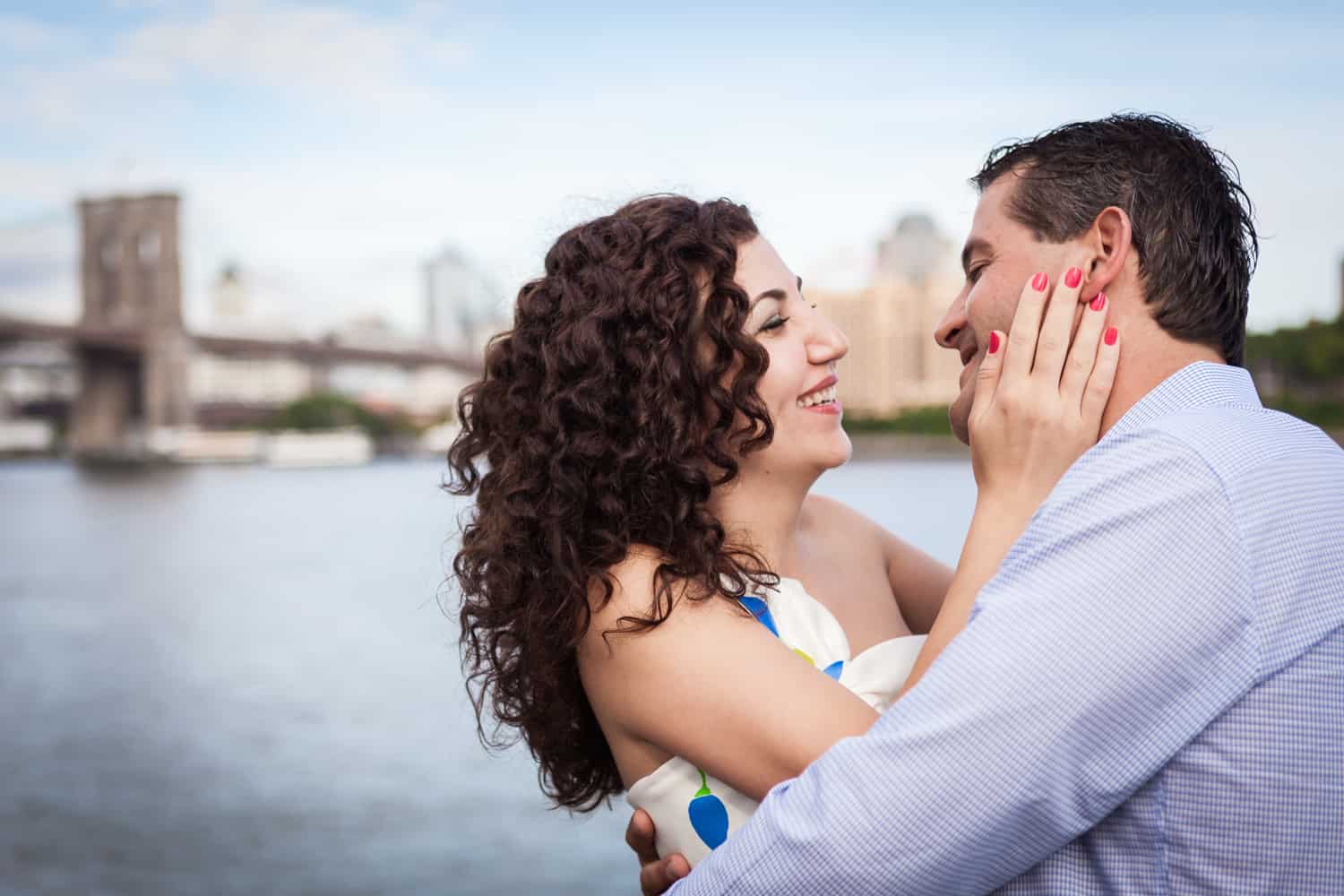Financial District engagement photos of woman grasping man's face