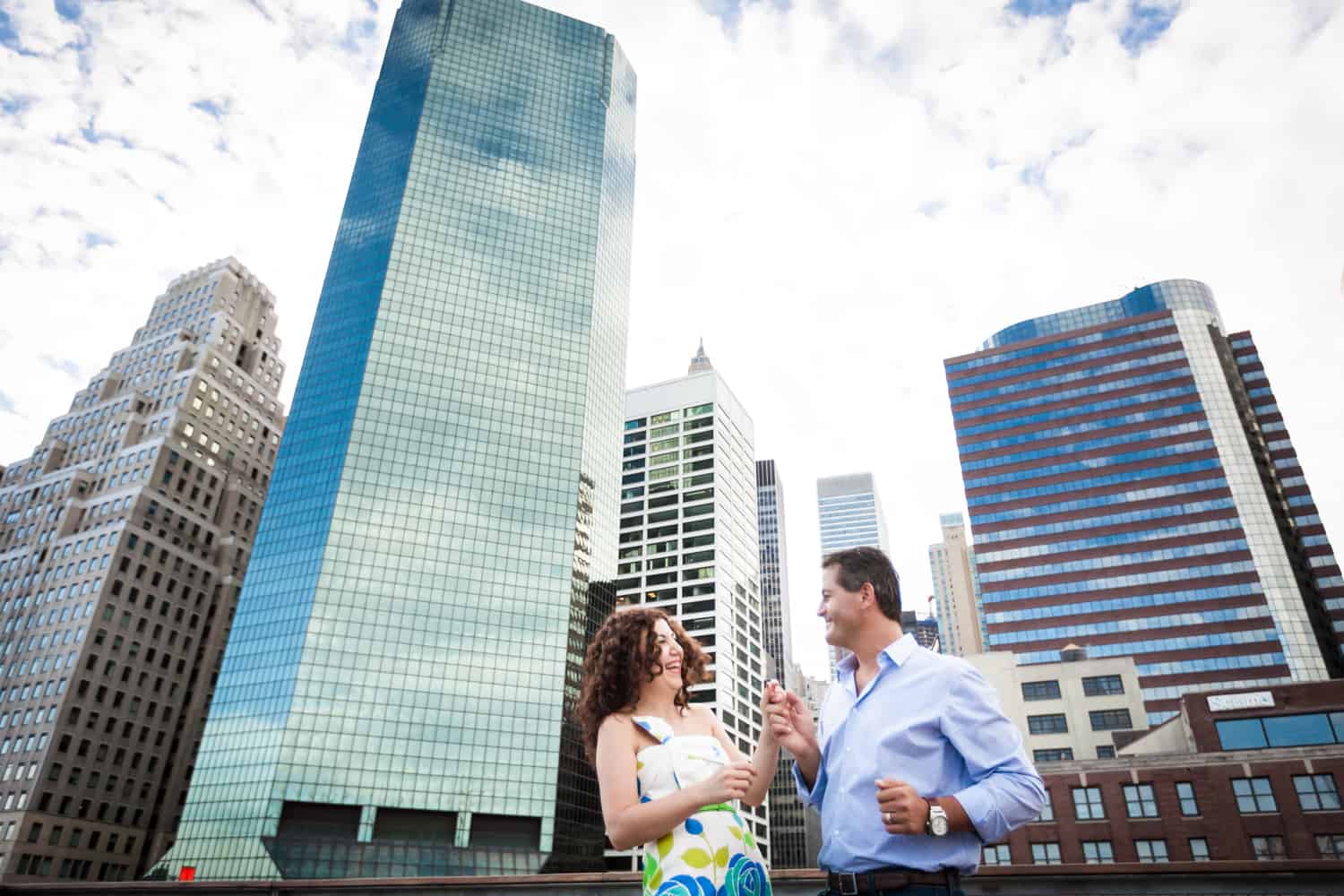 Financial District engagement photos of couple dancing in front of NYC skyscrapers