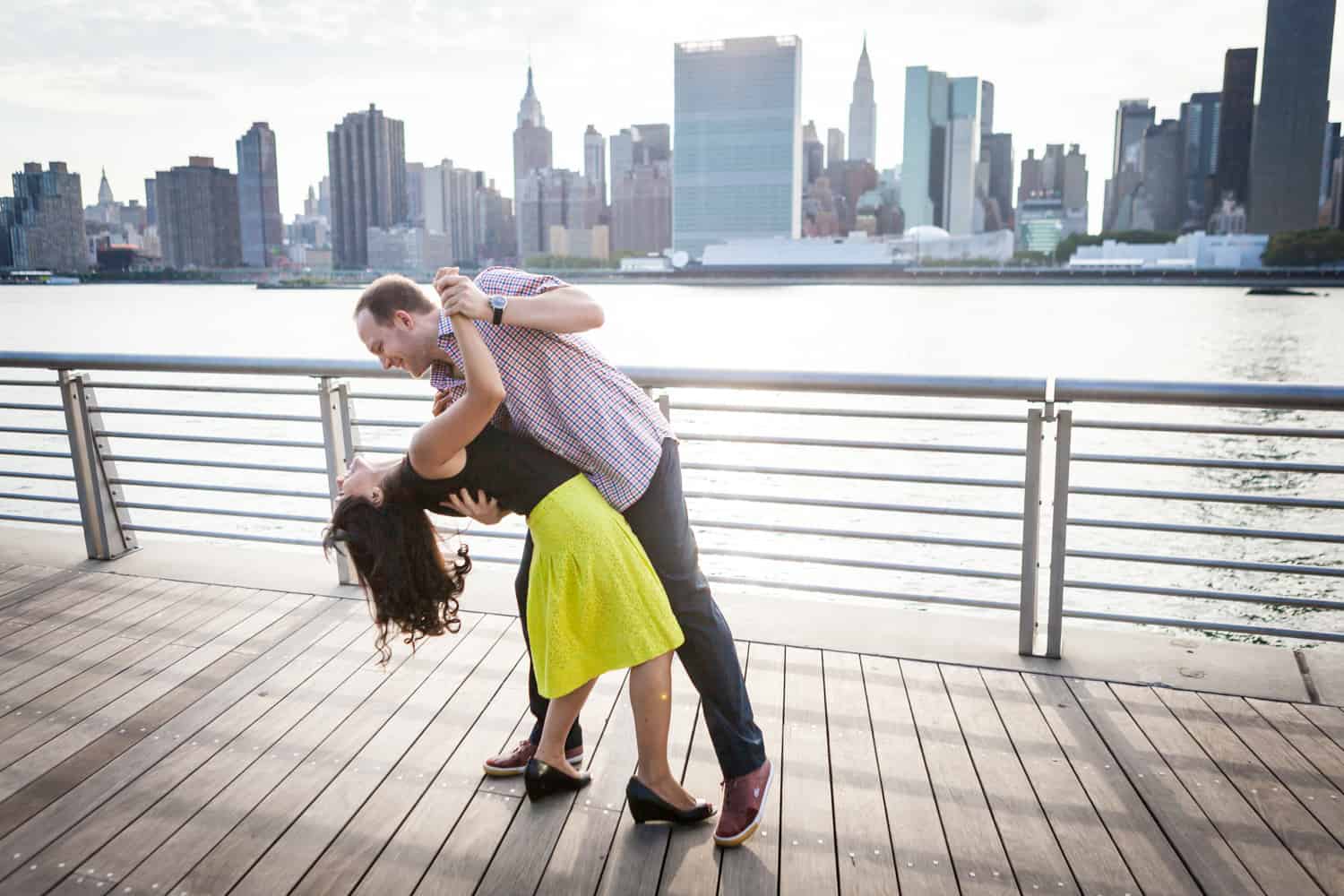 Couple dancing on boardwalk at a Gantry Plaza State Park engagement shoot