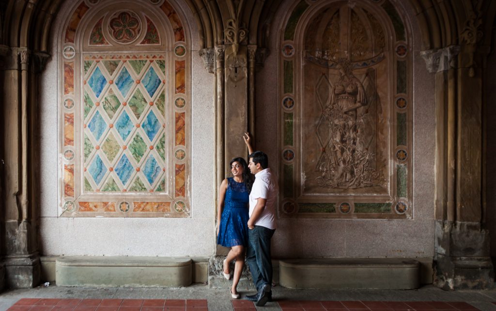 Couple leaning on wall of mosaic arch