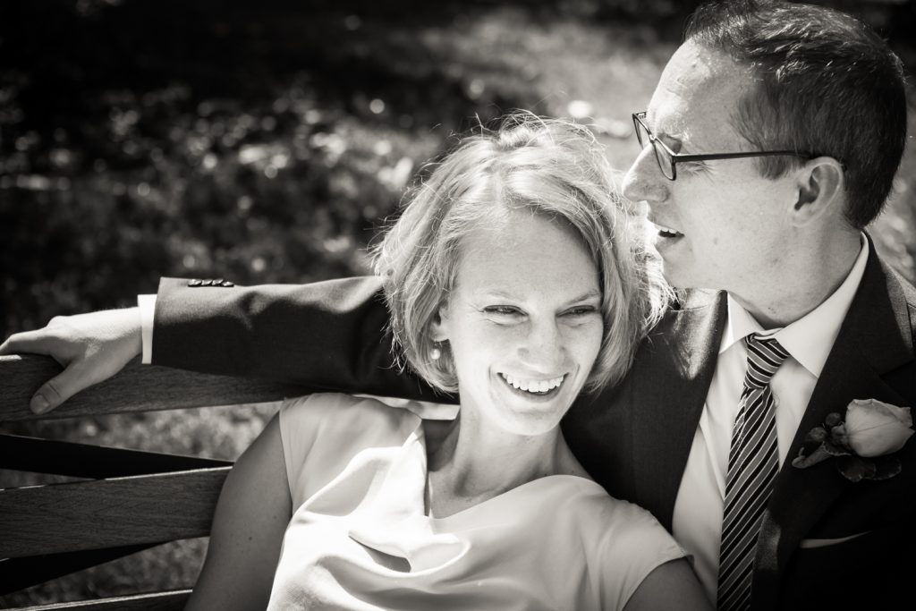 Black and white photo of bride lounging in groom's lap